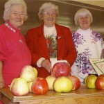 The Bennet sisters displaying apples at Apple Festival 1999. On the left is Evelyn Lee, who is still an active Pie Lady. In the middle is Mary Mollett, who wrote 2 lovely cook books, AN APPLE A DAY COOKBOOK, just based on apples.. Daughter, Terry Manuck, is still selling those cookbooks. On the right is the late, June Stevens, who raised and sold beautiful flowers near the Beaver Point Hall. Photo by Derek Lundy.
